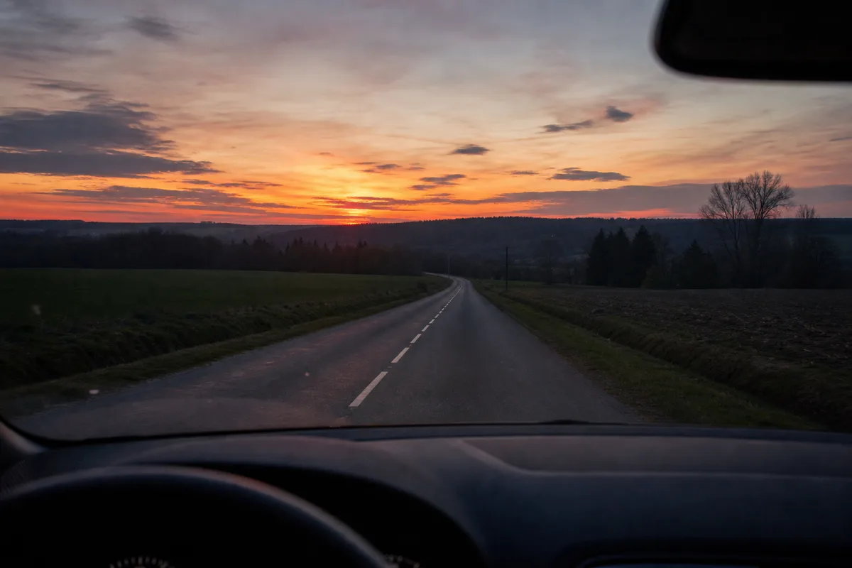 Route de campagne déserte à la tombée du jour, vue depuis l&rsquo;intérieur d&rsquo;un véhicule