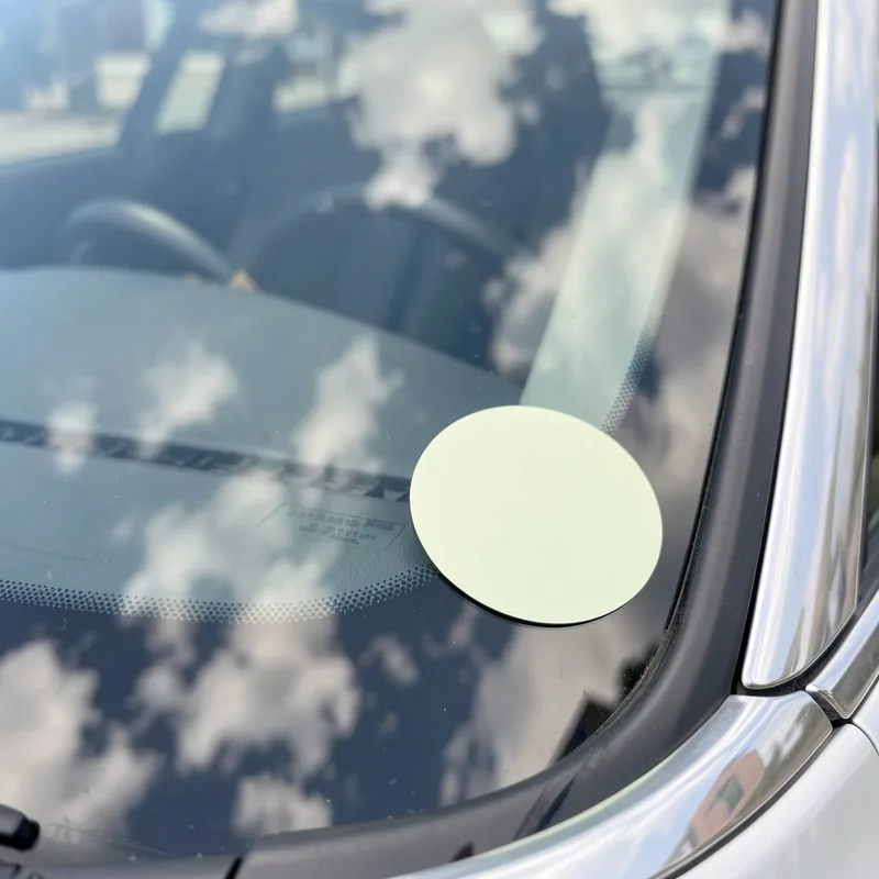Pastille Crit&rsquo;Air apposée en bas à droite du pare-brise d&rsquo;une voiture garée en ville